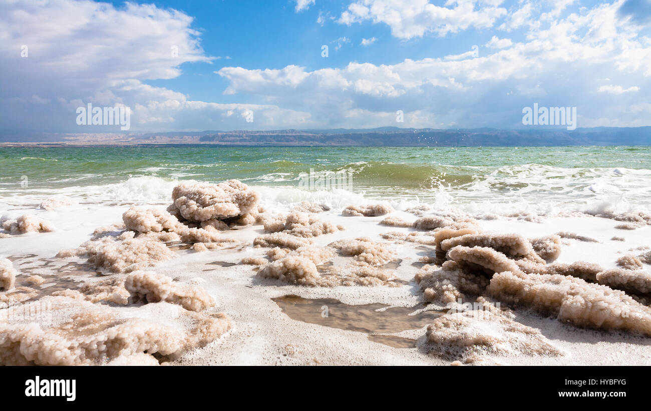 Travel to Middle East country Kingdom of Jordan - pieces of crystalline salt on surface of Dead Sea coastline in winter Stock Photo
