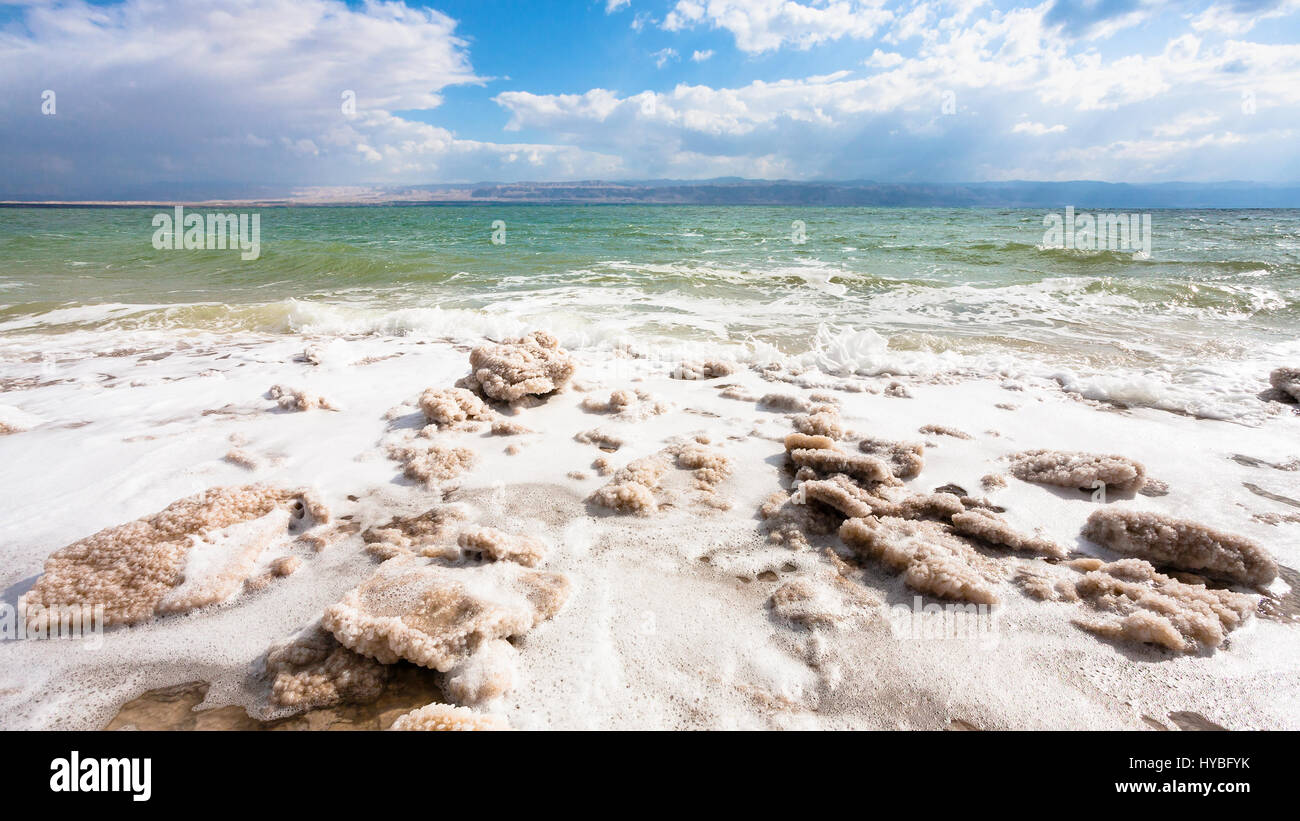 Travel to Middle East country Kingdom of Jordan - pieces of crystalline salt on surface of Dead Sea shore in winter Stock Photo