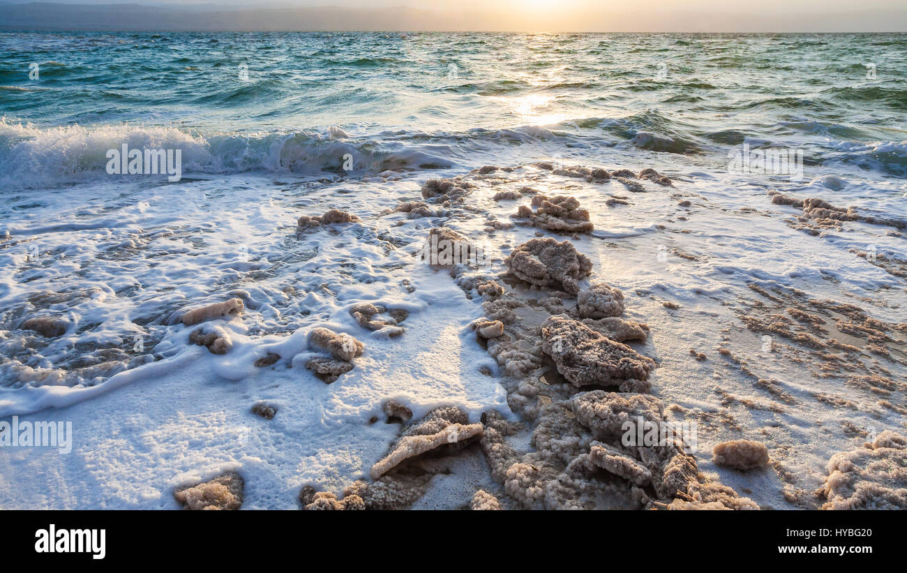 Travel to Middle East country Kingdom of Jordan - crystals of salt on shore of Dead Sea on winter sunset Stock Photo