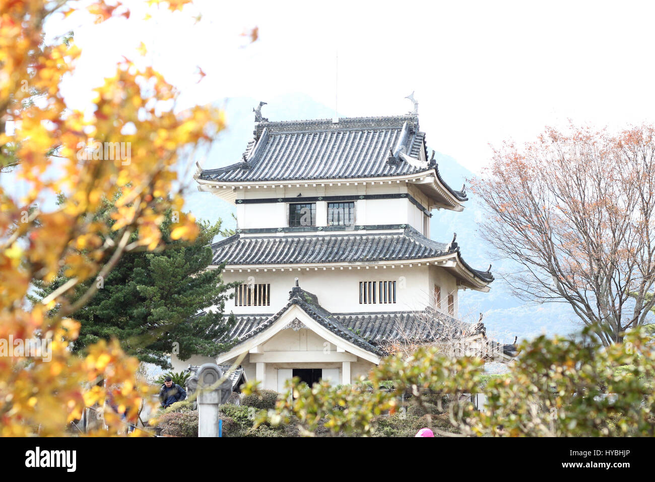 A quaint traditional building next to Shimabara Castle against a backdrop of mountains Stock Photo