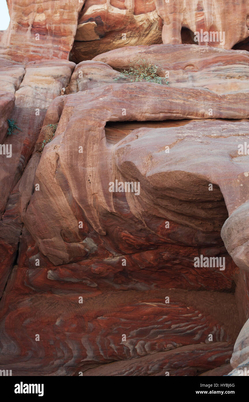 Veins of different shapes, colors and shades on the red rocks of the Royal Tombs, funerary structures carved into the rock face in the city of Petra Stock Photo