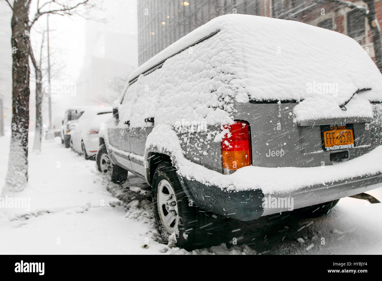 A Jeep SUV stands parked in the streets of Manhattan during a snowfall. Stock Photo