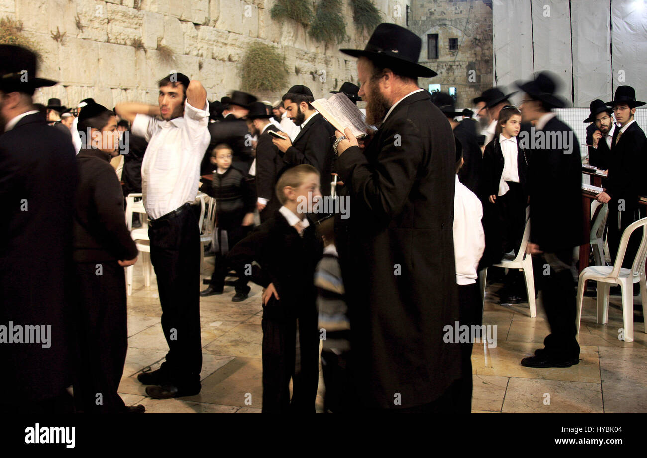 Jewish men are praying by the Western Wall - one of the holiest sites of Jewish religion. Stock Photo