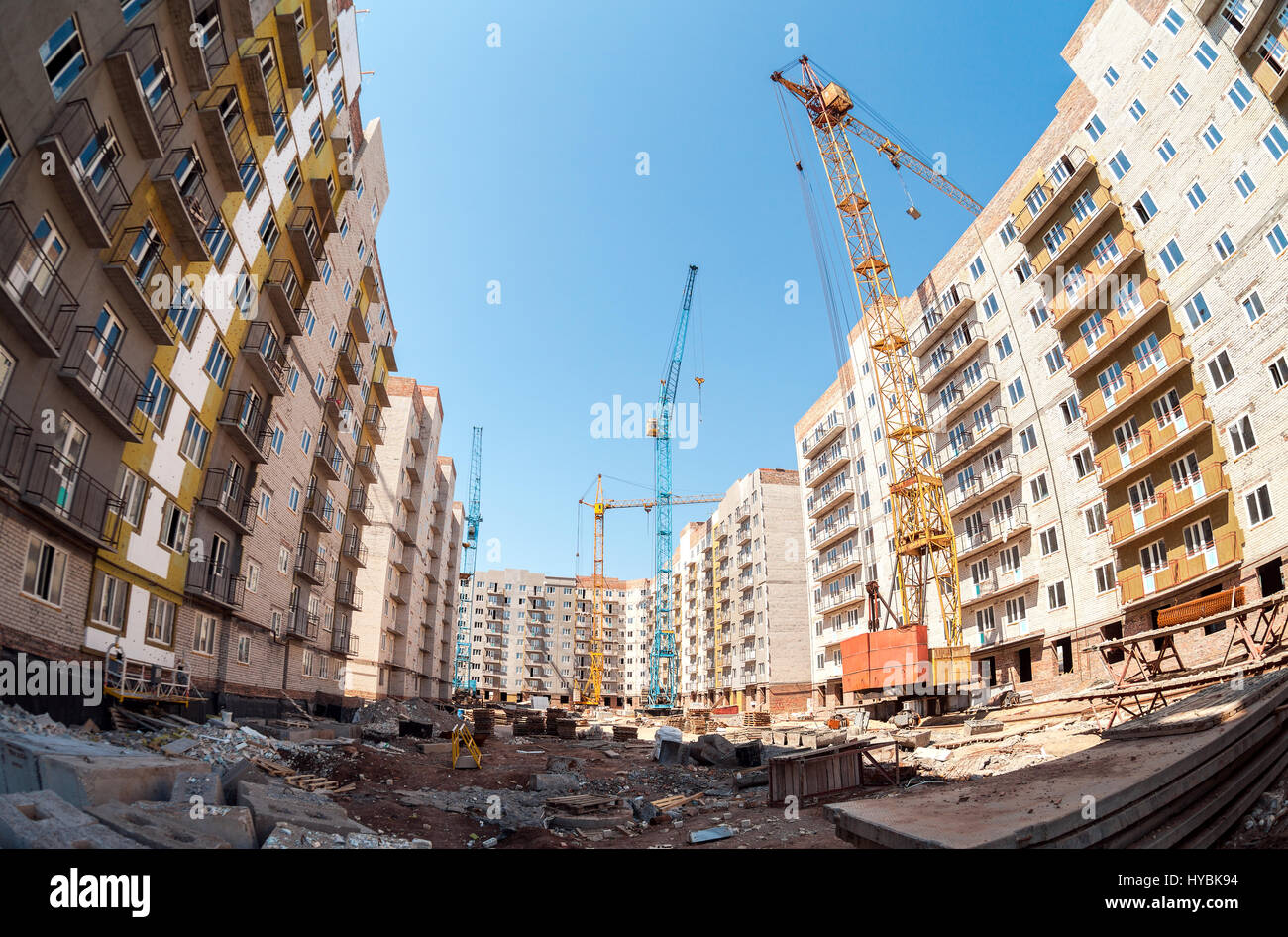 New tall apartment buildings under construction with cranes against