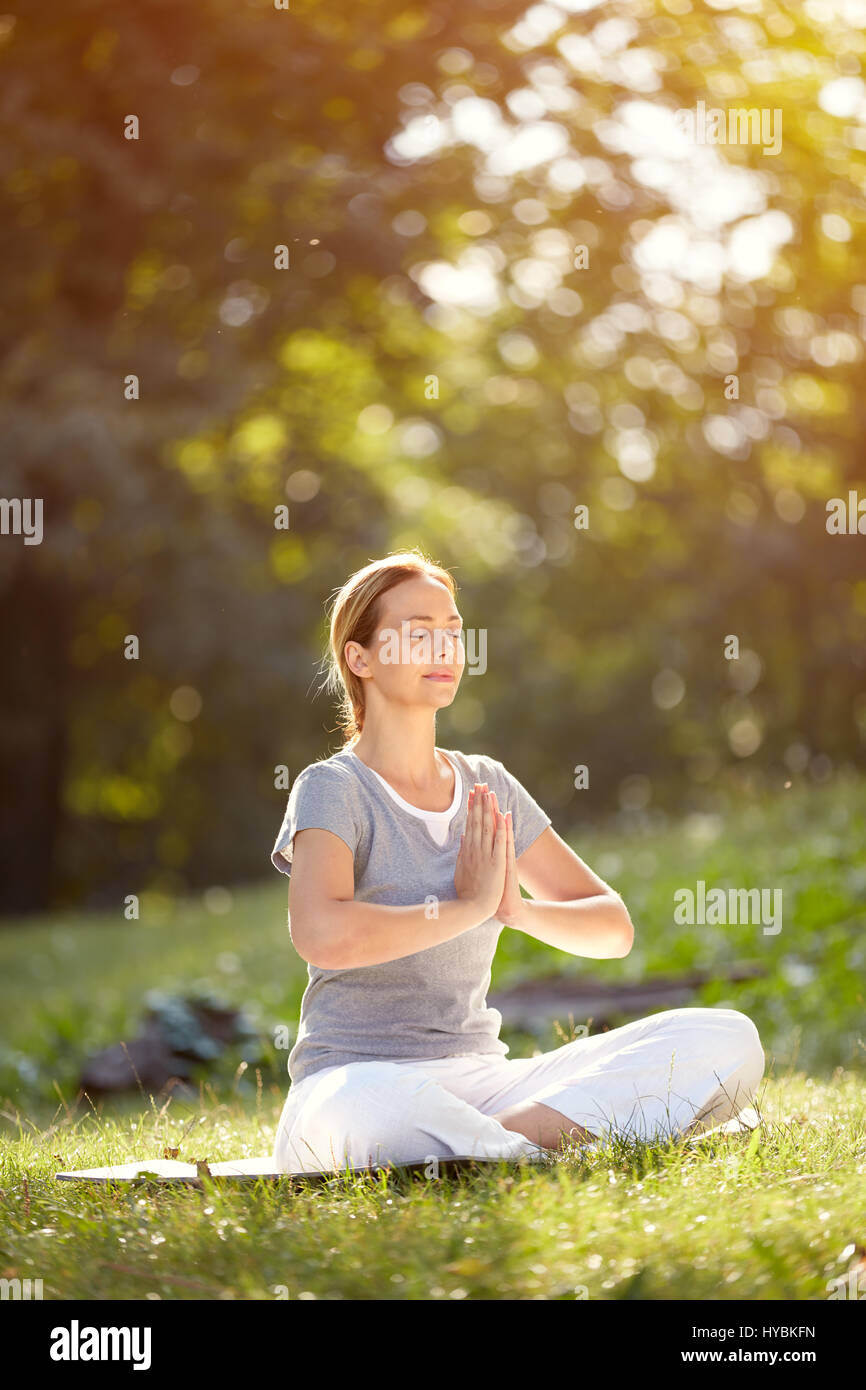 Calm woman meditating in yoga pose in green nature Stock Photo - Alamy
