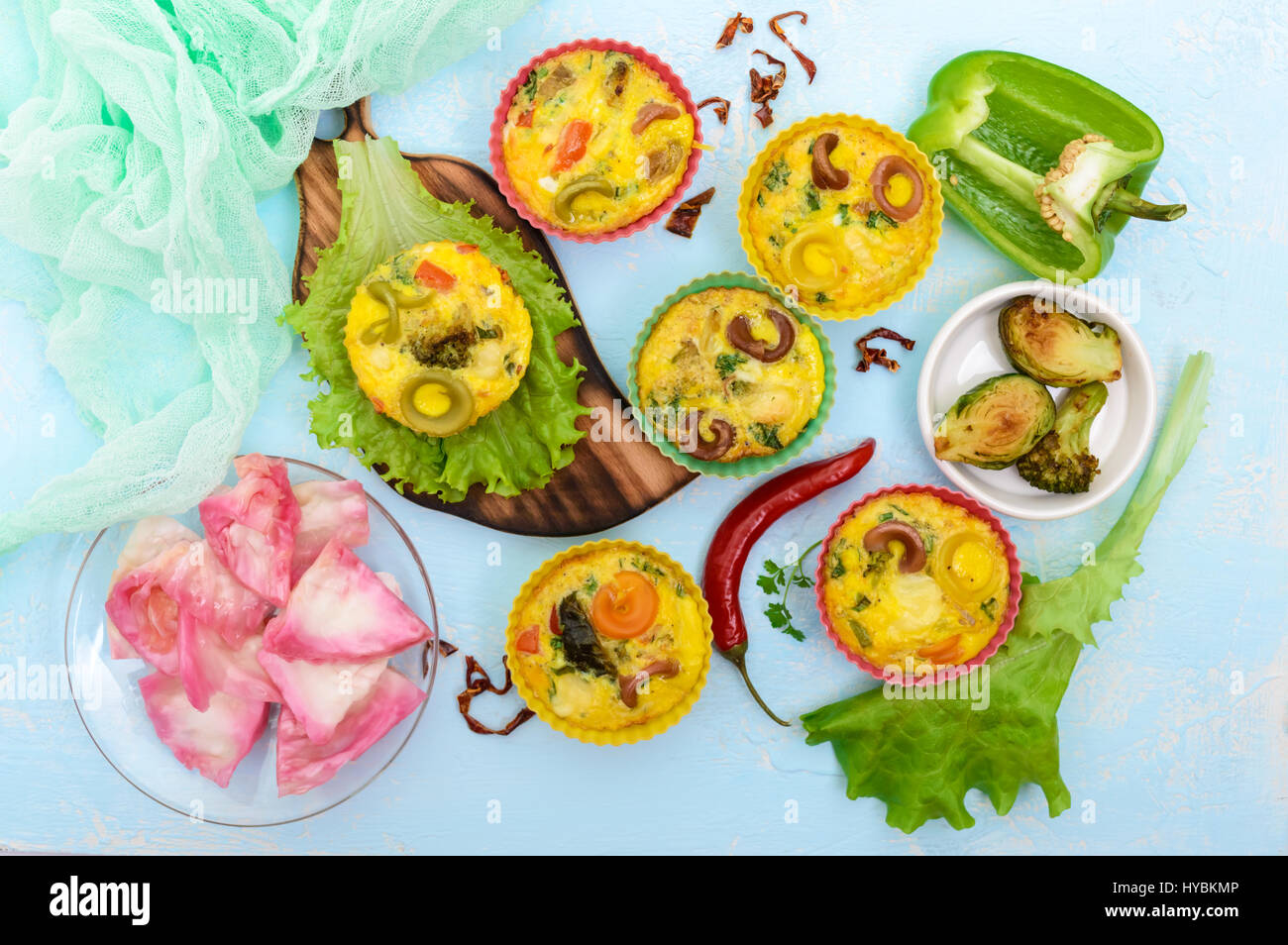 Omelette with colored pasta, mushrooms, vegetables and herbs, cooked in the form of mafins. The top view. Breakfast. Stock Photo