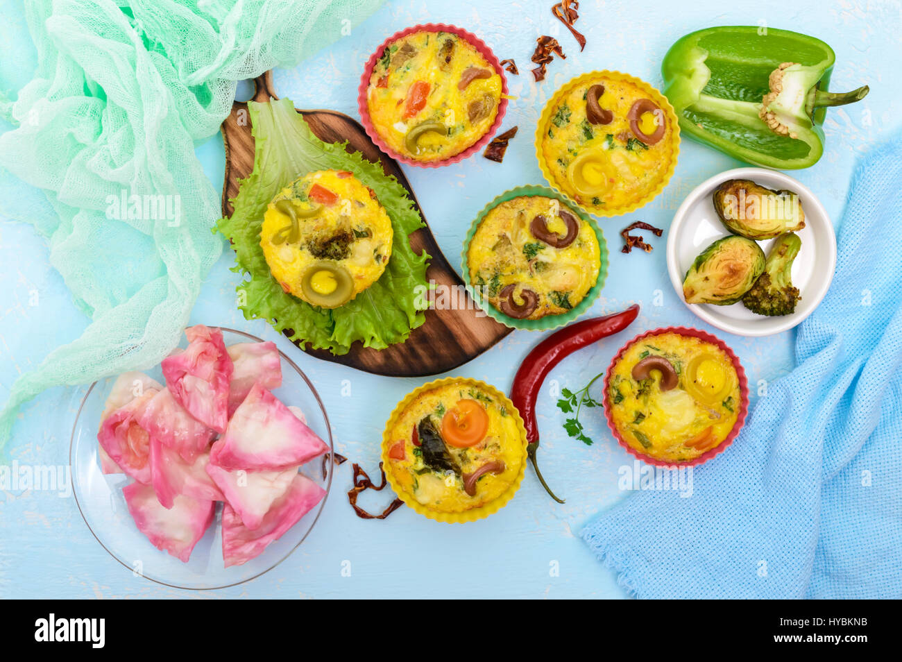 Omelette with colored pasta, mushrooms, vegetables and herbs, cooked in the form of mafins. The top view. Breakfast. Stock Photo