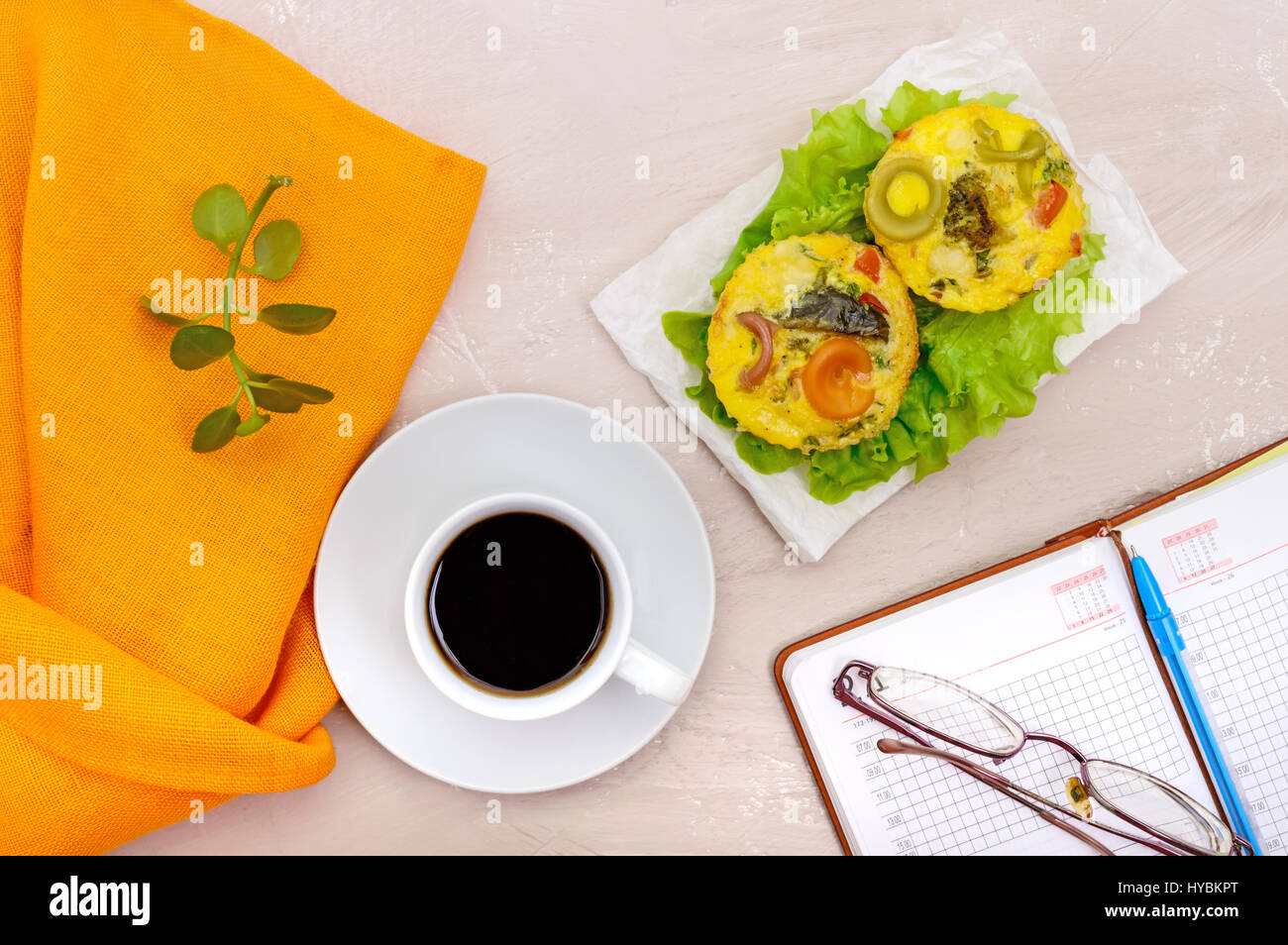 Omelette with colored pasta, mushrooms, vegetables and herbs, cooked in the form of mafins and a cup of espresso. Breakfast. The top view Stock Photo