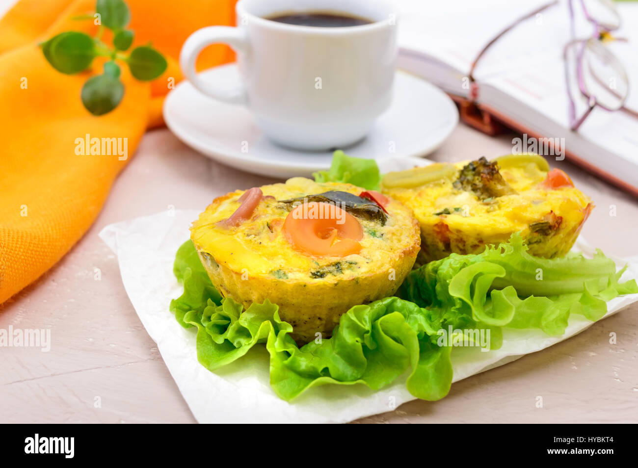Omelette with colored pasta, mushrooms, vegetables and herbs, cooked in the form of mafins and a cup of espresso. Breakfast. Stock Photo
