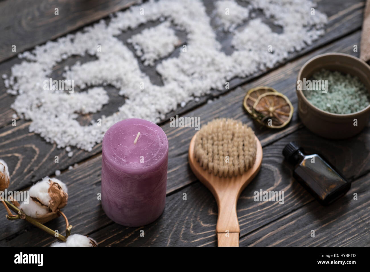 Word SPA with sea salt. Beauty cosmetic products on dark wooden table. Professional massage concept. Top perspective view Stock Photo