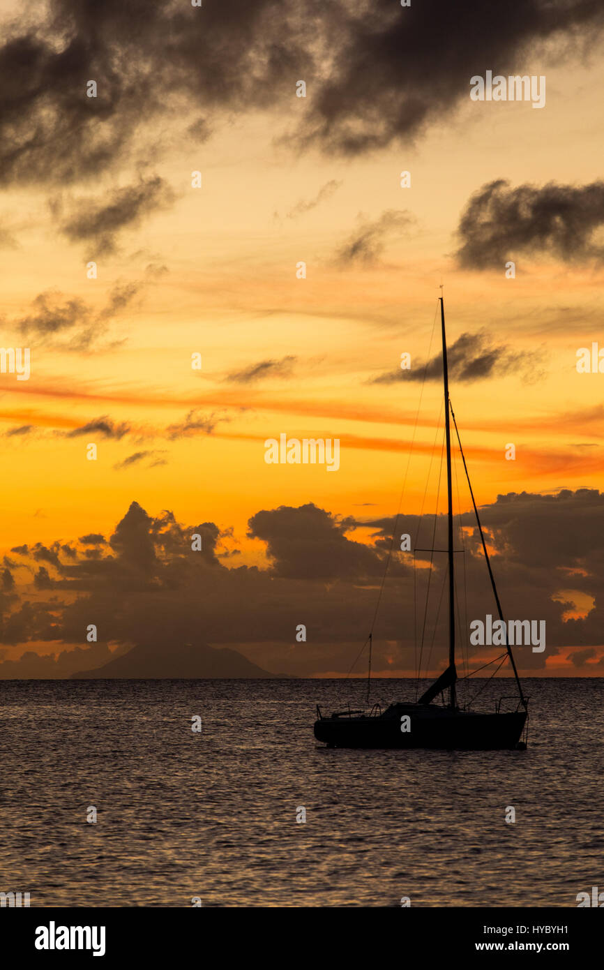 Sailboat silhouetted against sunset in Dickenson Bay, Antigua. Stock Photo