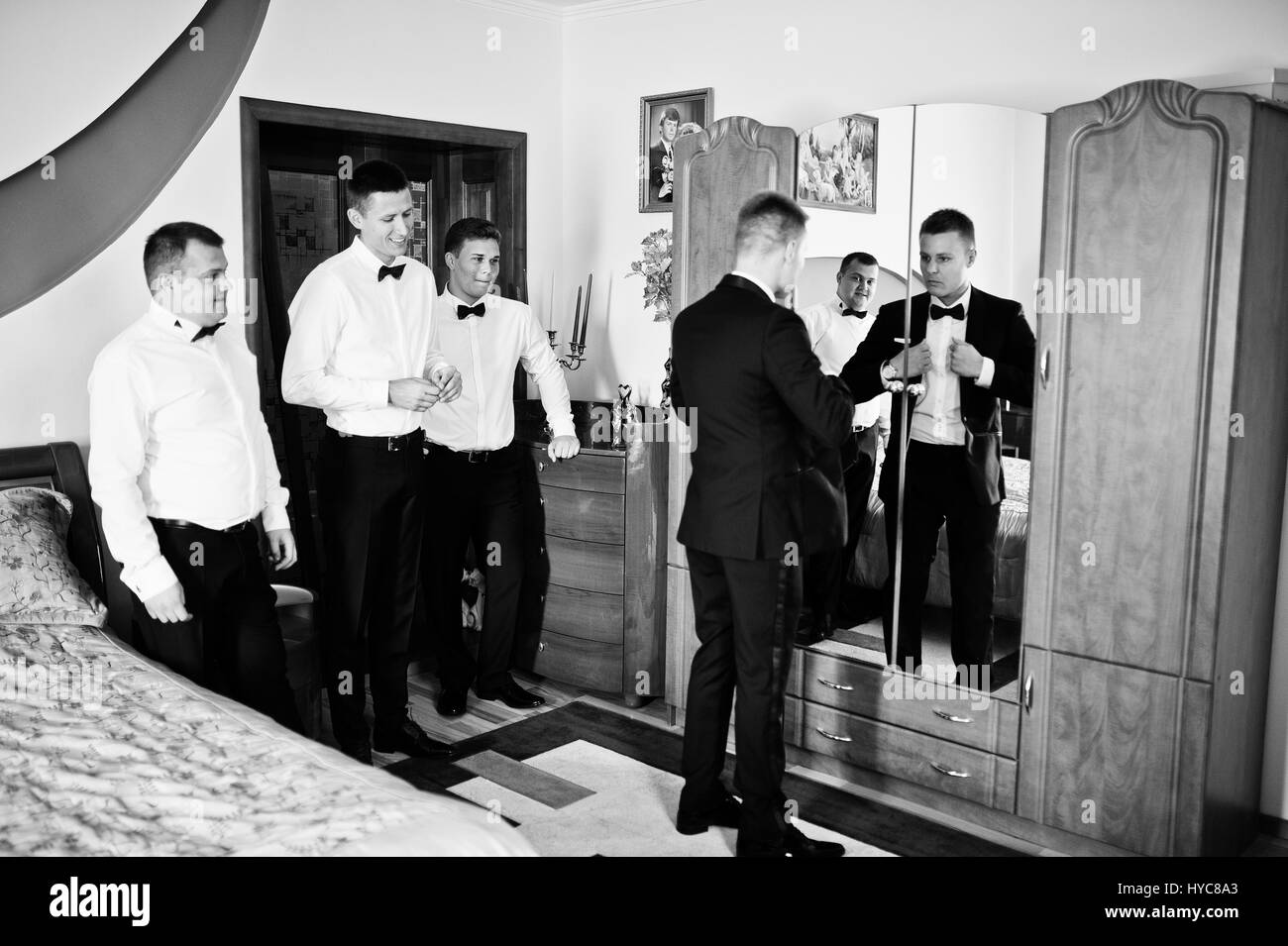 Groom wears on his room at morning wedding with best mans Stock Photo