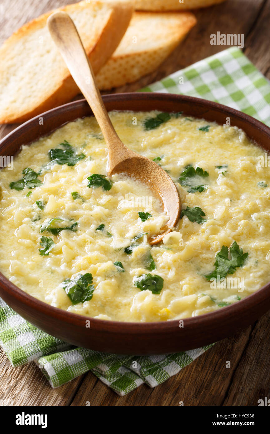 Italian egg soup stracciatella with farfalline pasta and parmesan close-up in a bowl. vertical Stock Photo