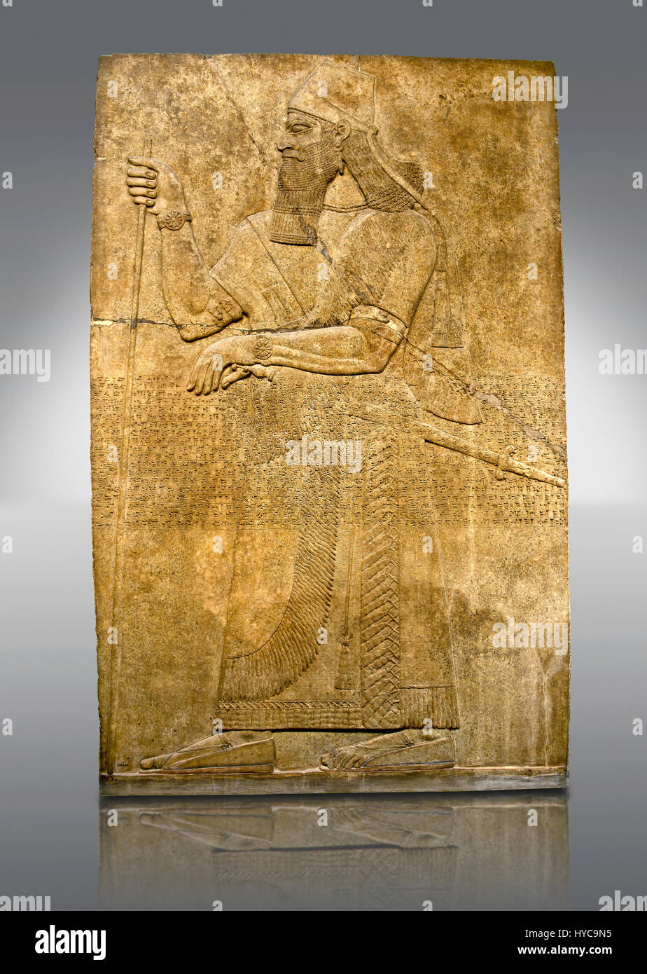 Assyrian relief sculpture panel  of King Ashurnaspiral II with his sword and a staff. The panel is possibly from his private apartments..  From Nimrud Stock Photo