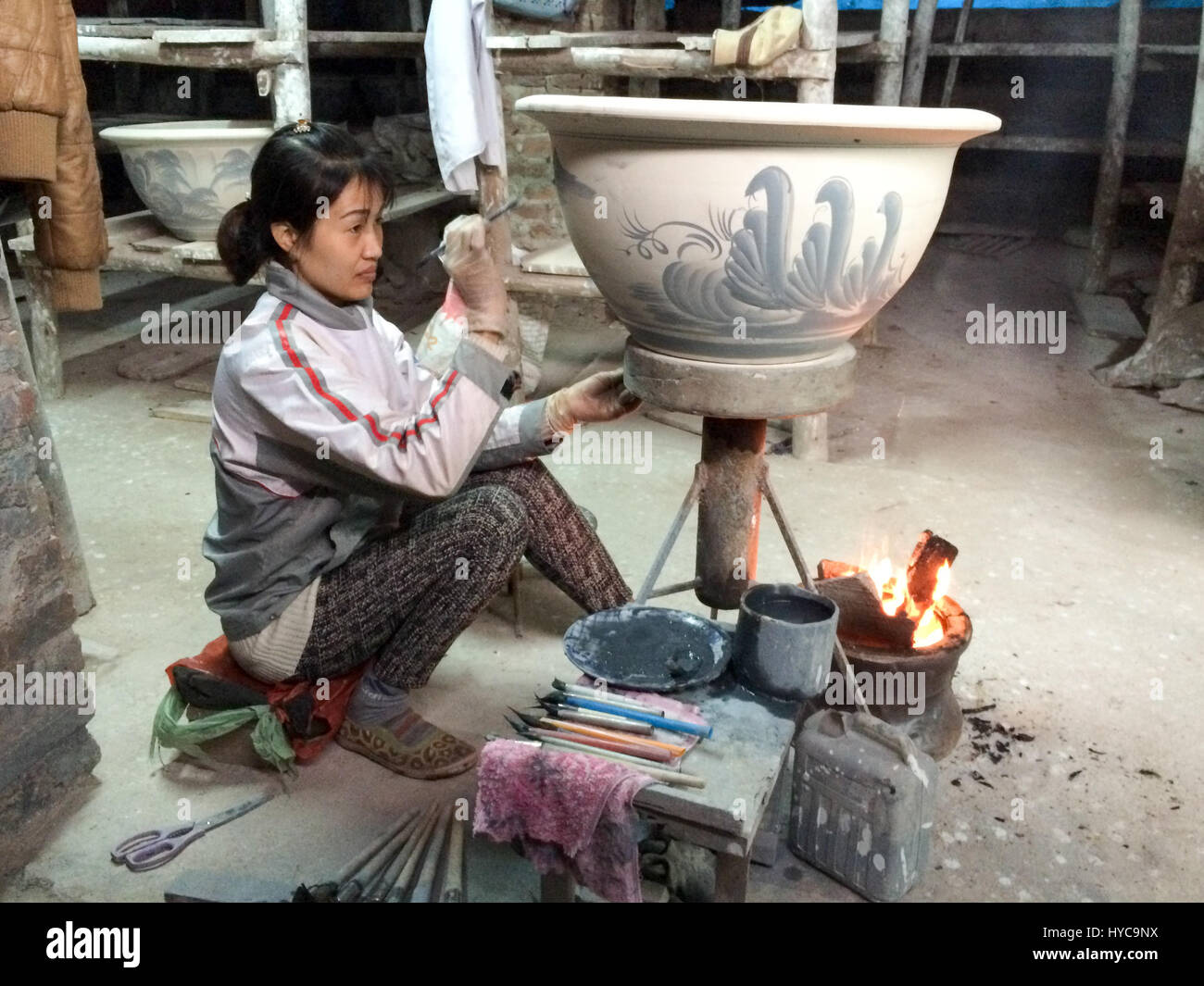 A young Vietnamese woman hand painting a vase Stock Photo