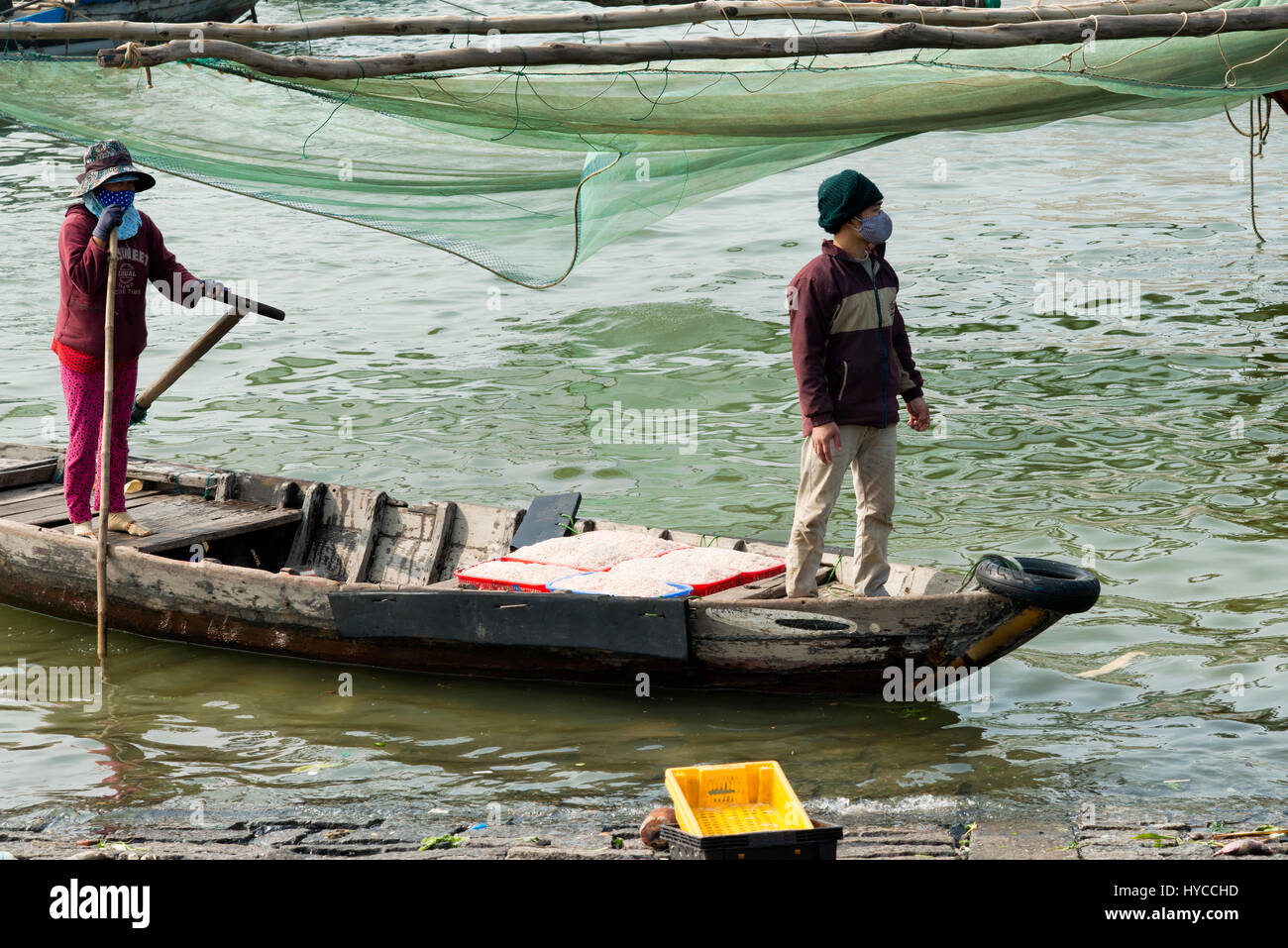 Vietnamese couple bringing buckets with shrimp catch to the dockside. December 26, 2013 - Da Nang, South Vietnam Stock Photo