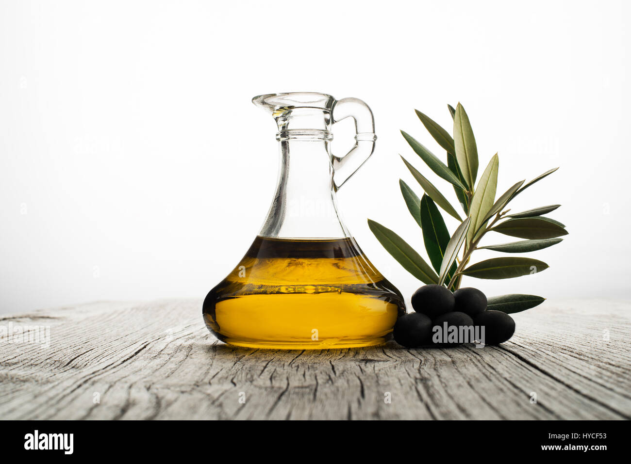 Olive oil and olive branch on the wooden table Stock Photo - Alamy