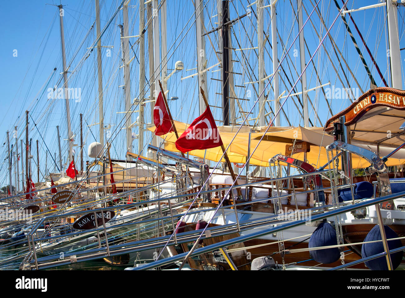 Many yachts parked at Bodrum marina. Turkish flags wave. A lot of masts are also in the view. Stock Photo
