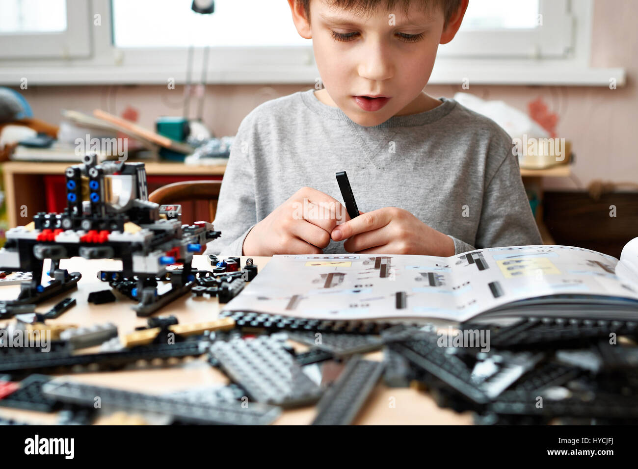 Little boy collects the children's plastic construction toys Stock Photo