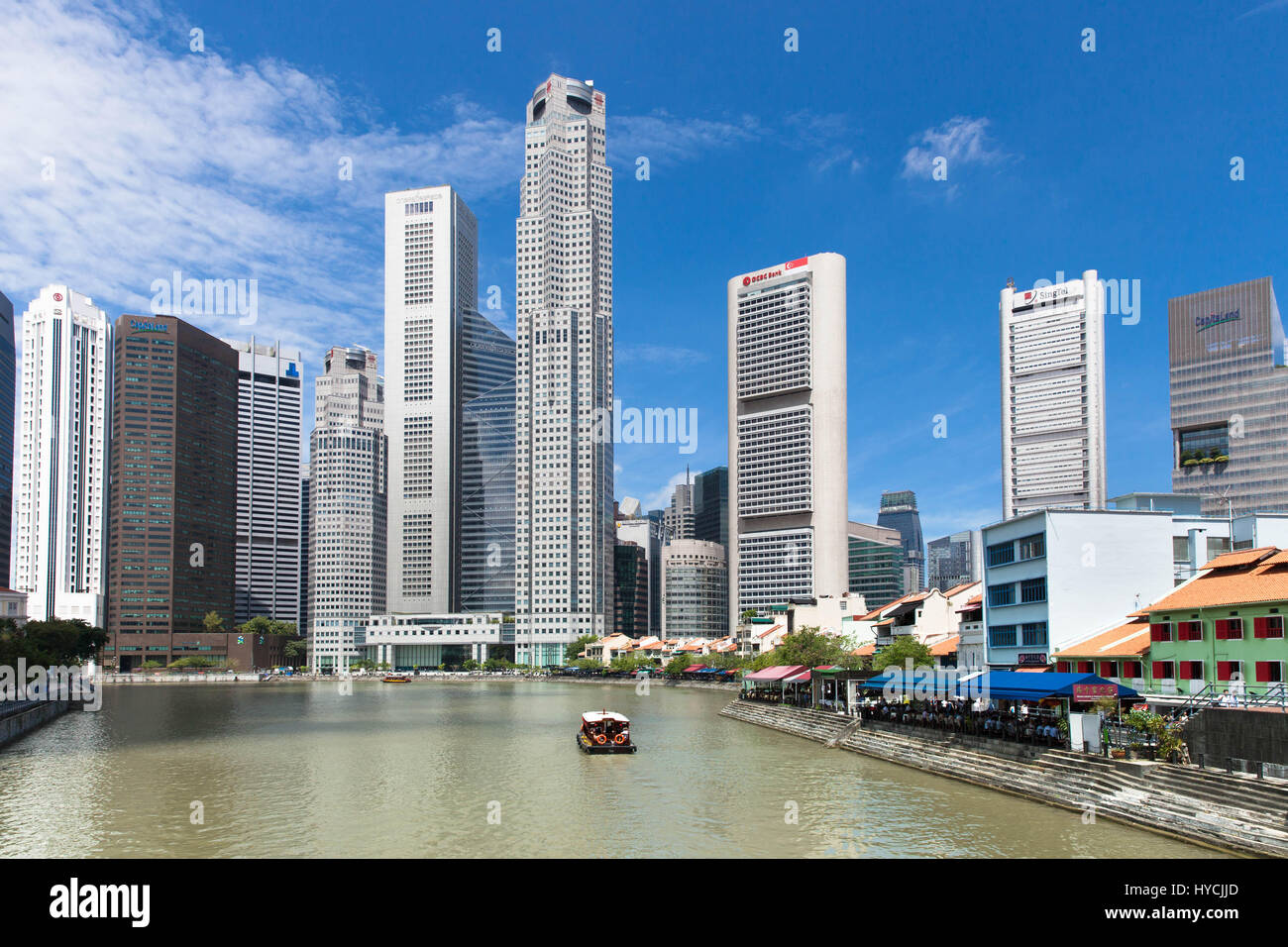 Singapore, July 07, 2013: Touristic boat floating down the Singapore river near the Boat Quay on July 07, 2013 in Singapore. Stock Photo