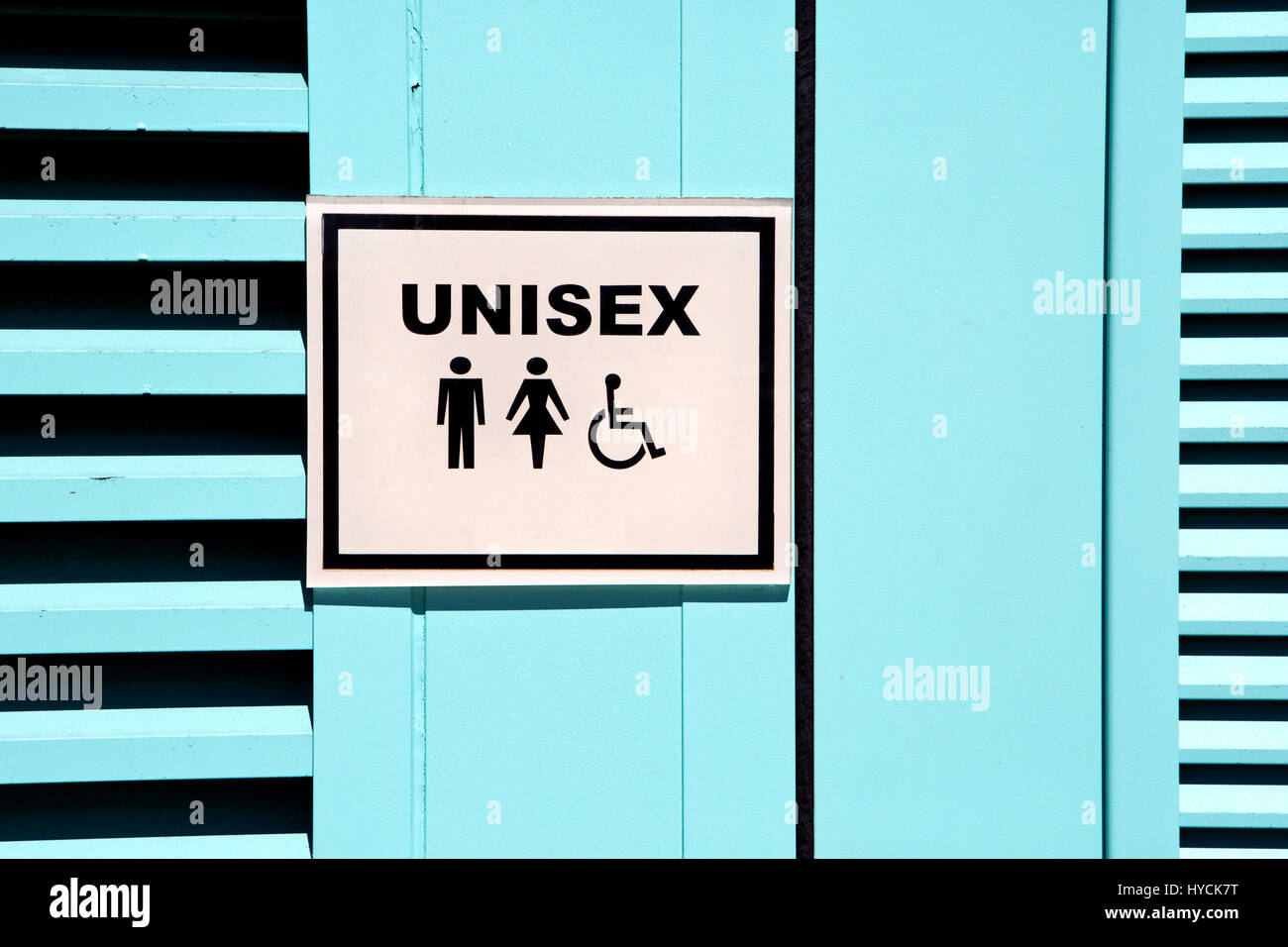 Unisex sign is posted on the outside of a public restroom door. Stock Photo