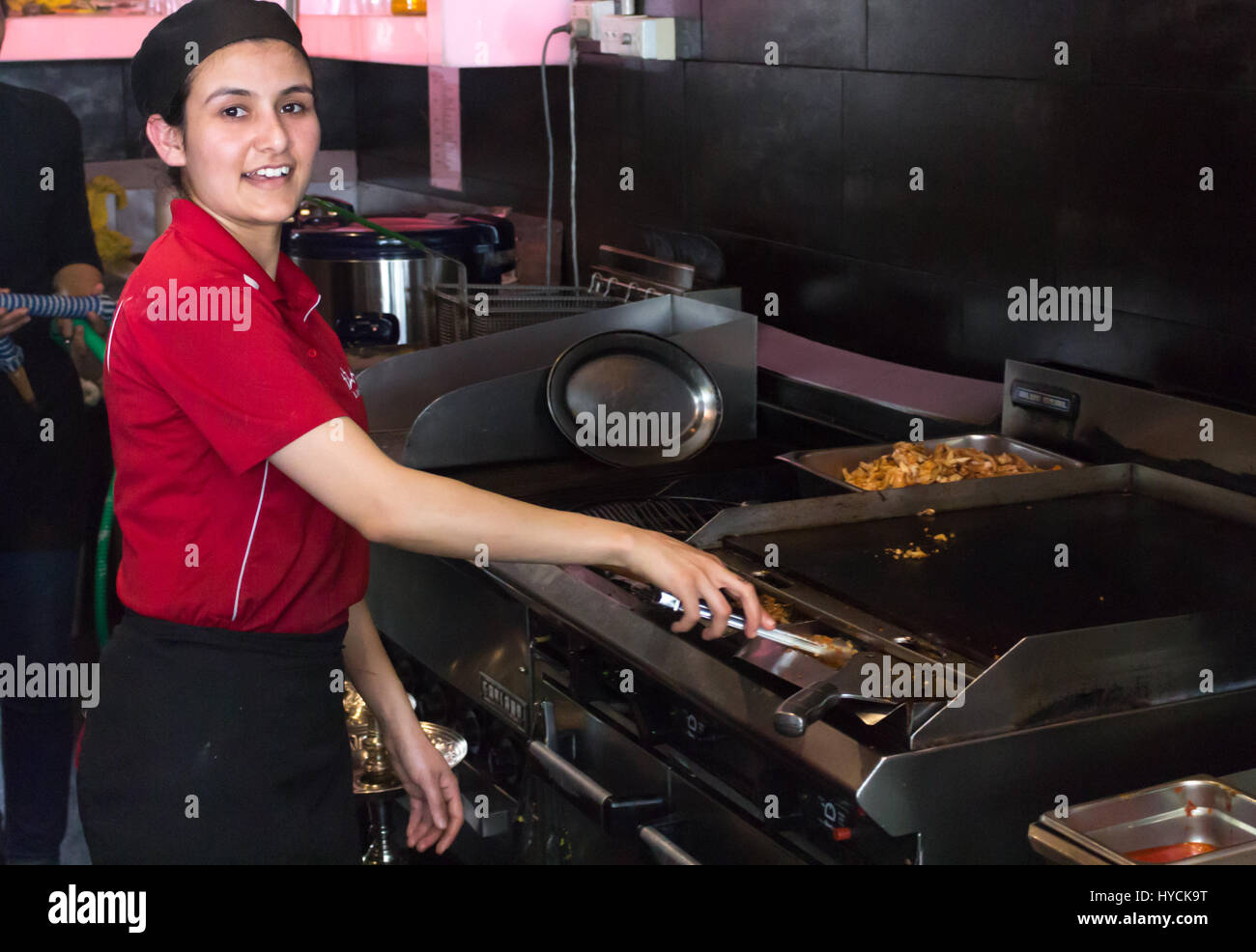 Auckland - February 17, 2017: A female cook working inside an asian restaurant in Auckand. Stock Photo