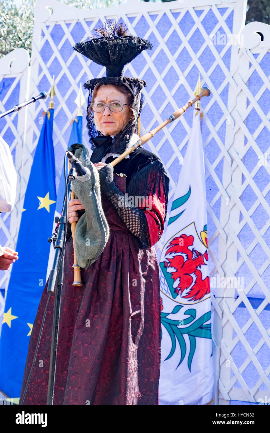 Female bagpipe player prepares to accompany traditional folk dancers in Nice, France for a public performance Stock Photo