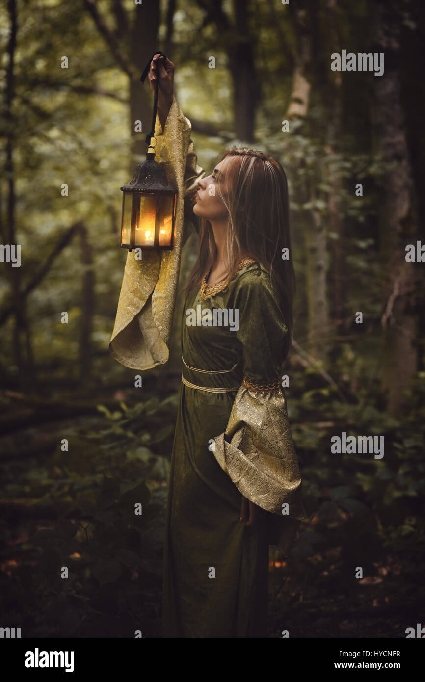 Beautiful woman walking in fairy forest with a lantern. Dark fantasy Stock Photo