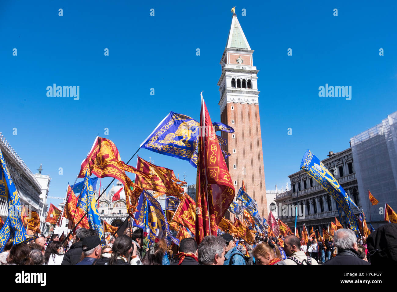 Celebrating the Saint's Day of Venice in the Piazza San Marco with flags and banners on a breezy sunny day Stock Photo