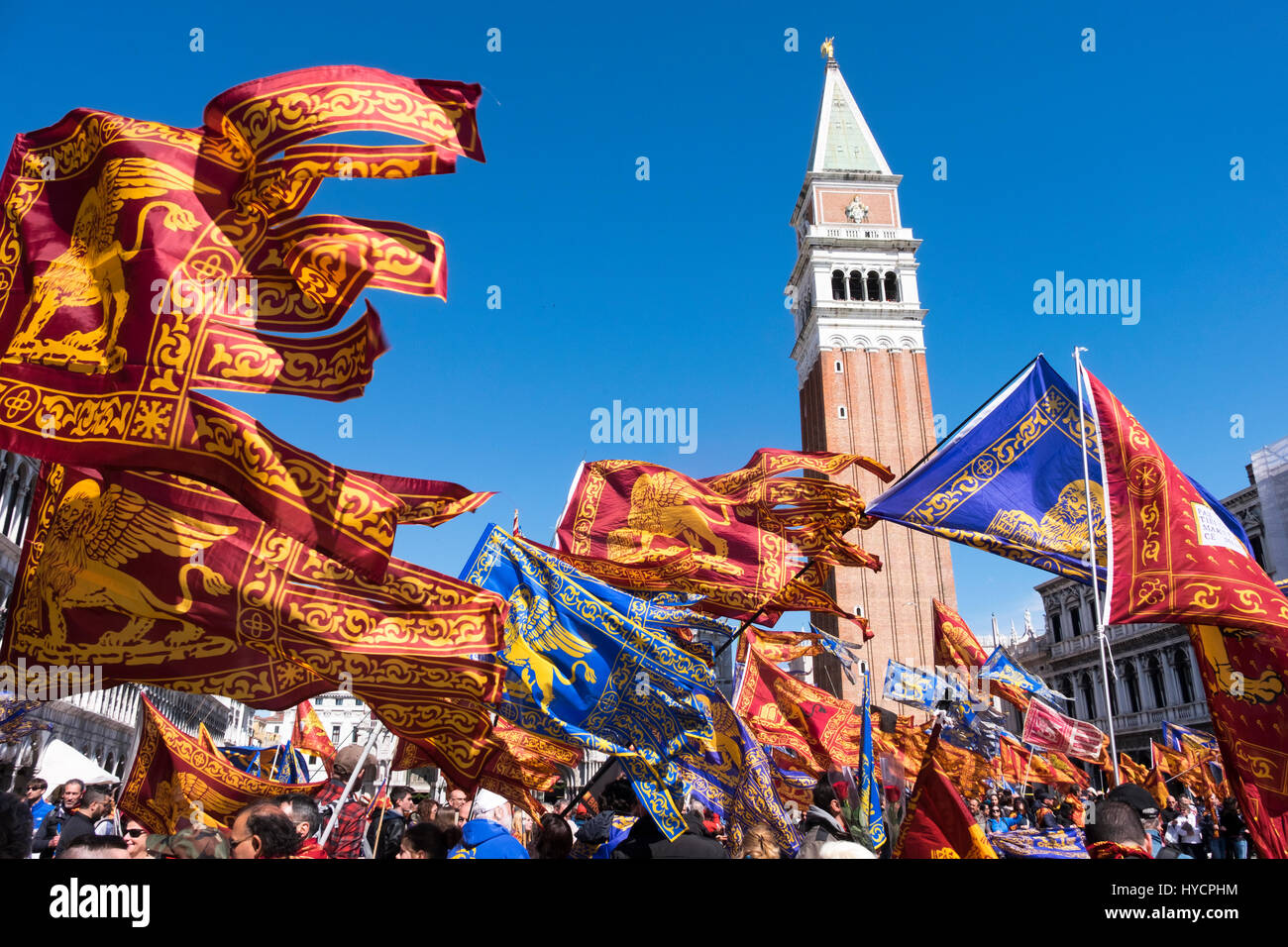 Celebrating the Saint's Day of Venice in the Piazza San Marco with flags and banners on a breezy sunny day Stock Photo