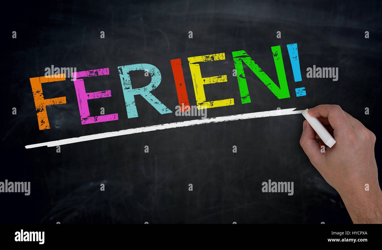 Ferien (in german Holiday) is written by hand on blackboard. Stock Photo