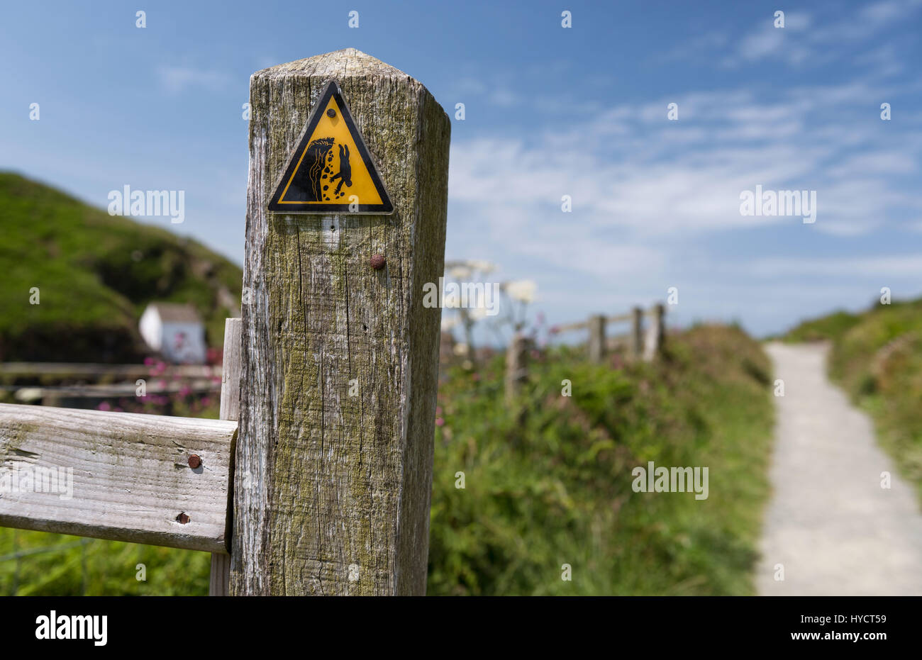 Fishguard, Wales - Dangerous cliff hazard warning triangle sign on coastal path Stock Photo