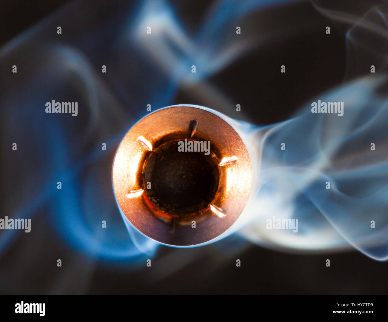 Hollow point with a copper jacket and smoke behind Stock Photo Alamy