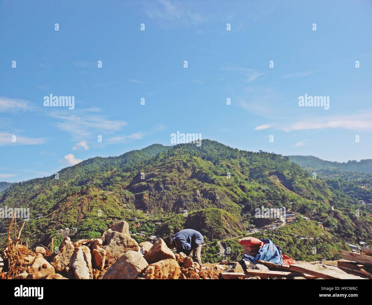 View of mountains with clear skies with a man working in the foreground Stock Photo