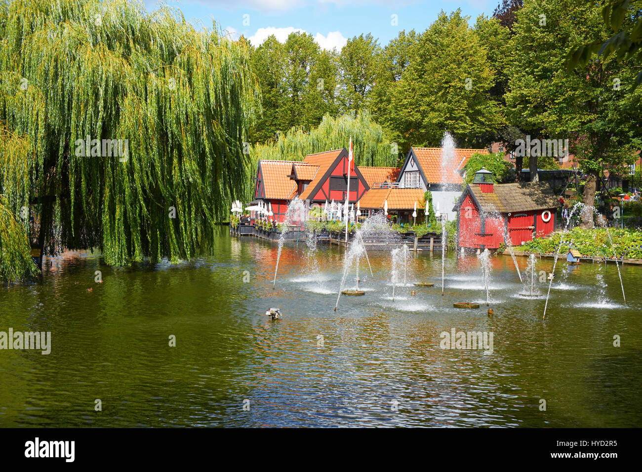 COPENHAGEN, DENMARK - AUGUST 22, 2014: A beautiful pond with fountain and   smal confortable restaurant in Tivoli gardens in Copenhagen, Denmark. Tivo Stock Photo