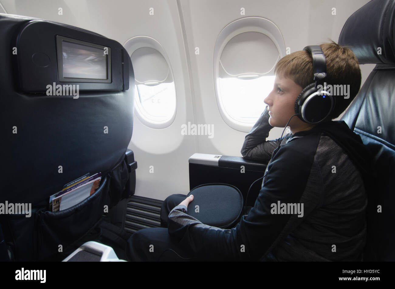 Boy watching tv in aero plane Stock Photo