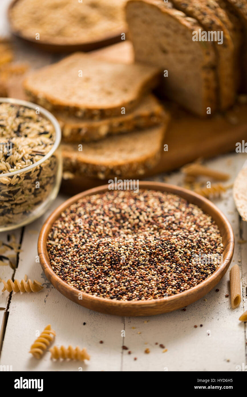 Quinoa in bowl and sliced brown bread in background Stock Photo