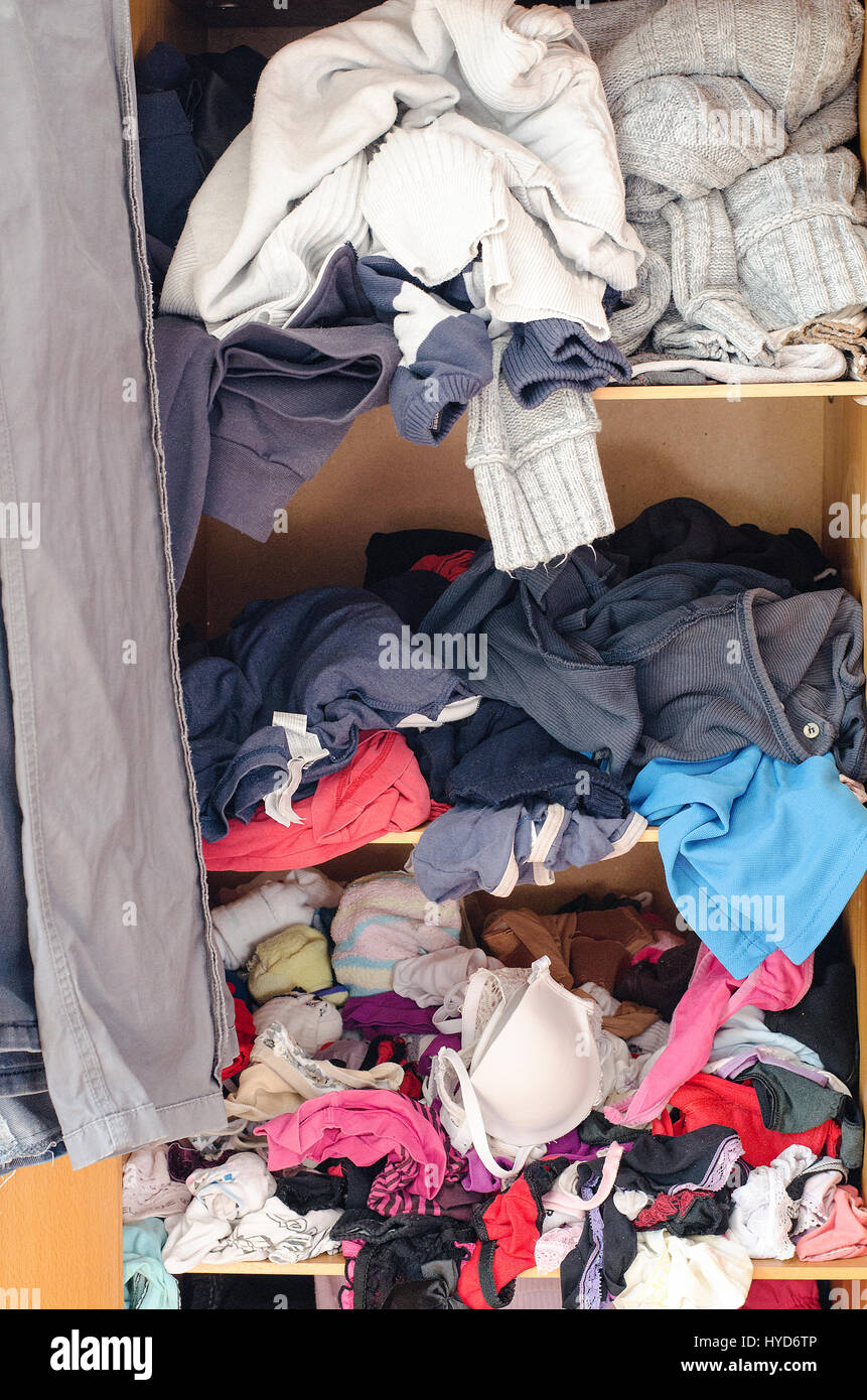 Pile of carelessly scattered clothes in wardrobe Stock Photo