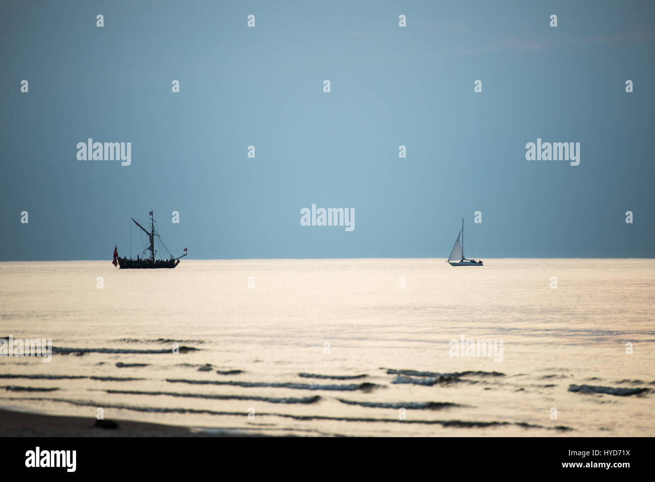 sea with waves and boats before sunset Stock Photo - Alamy