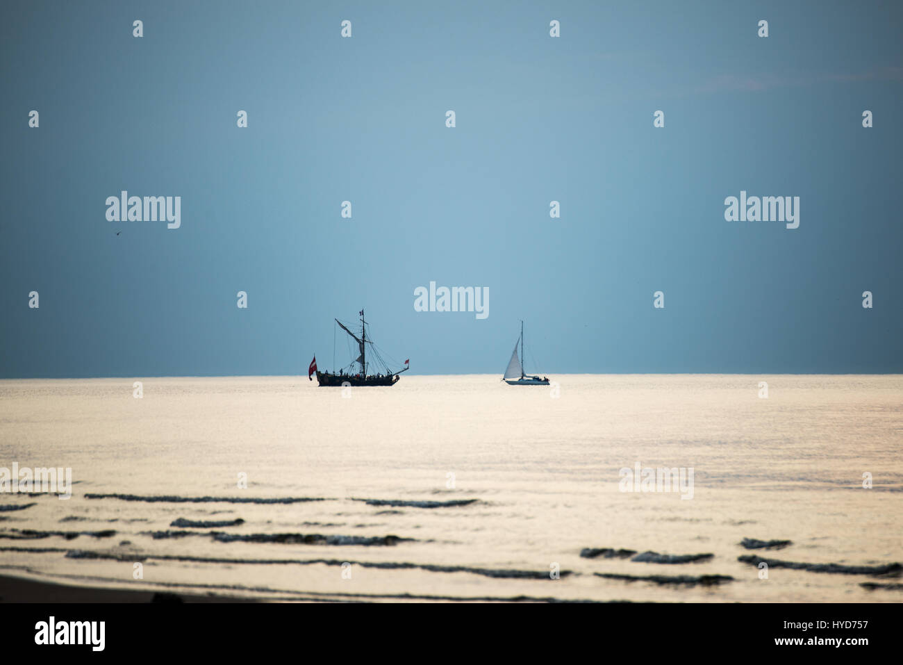 sea with waves and boats before sunset Stock Photo - Alamy