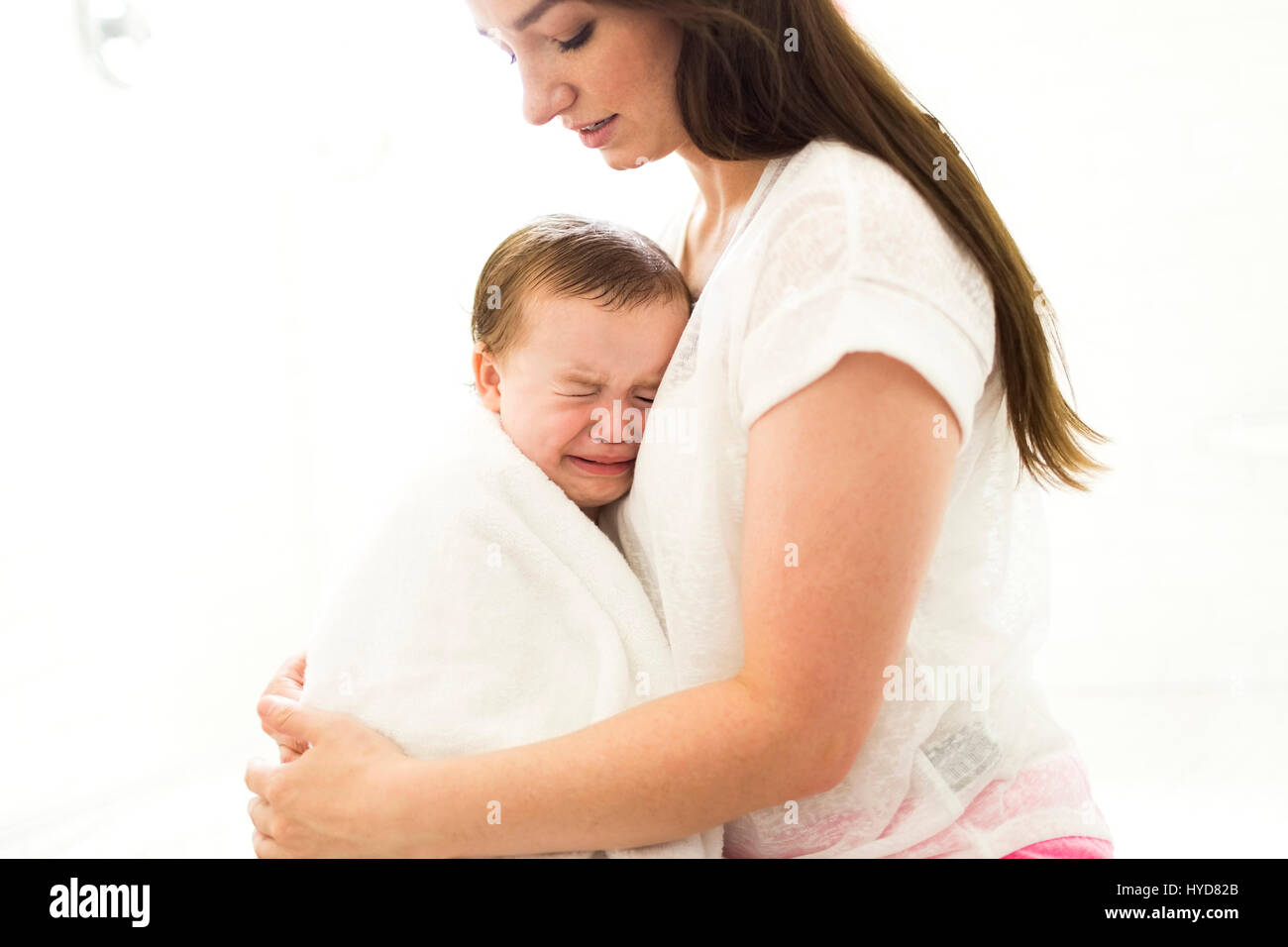 Mother embracing and consoling son (4-5) Stock Photo