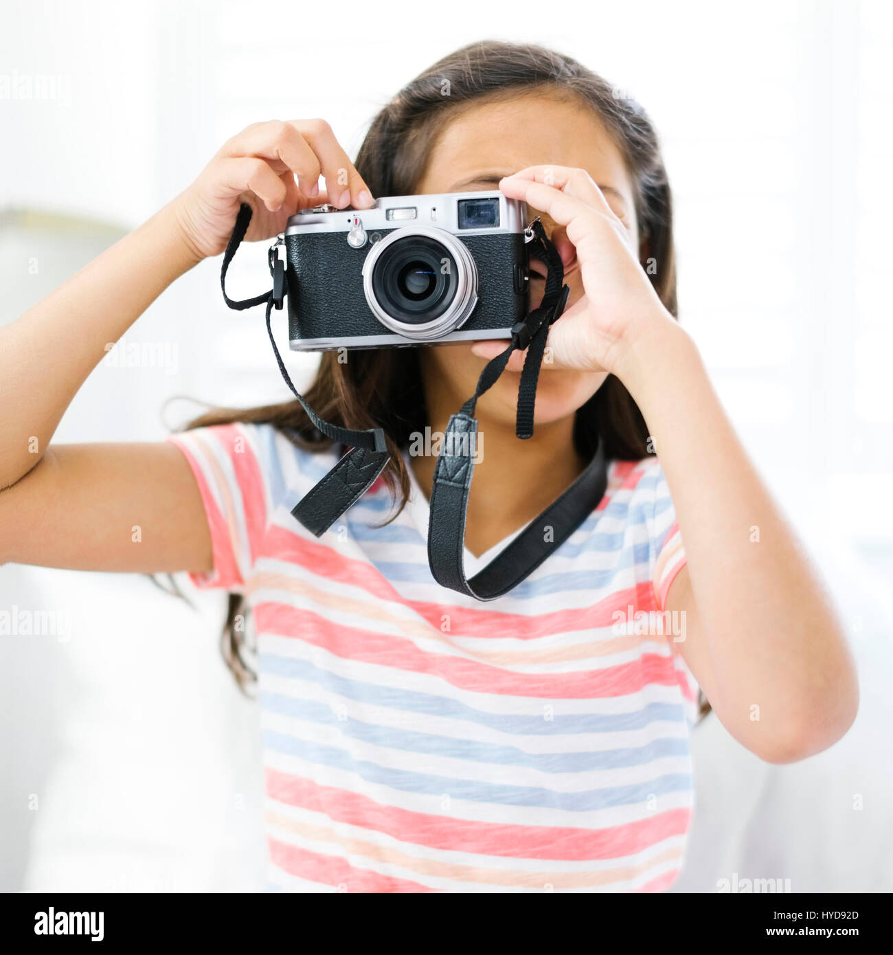 Girl (10-11)  holding camera and taking photo Stock Photo