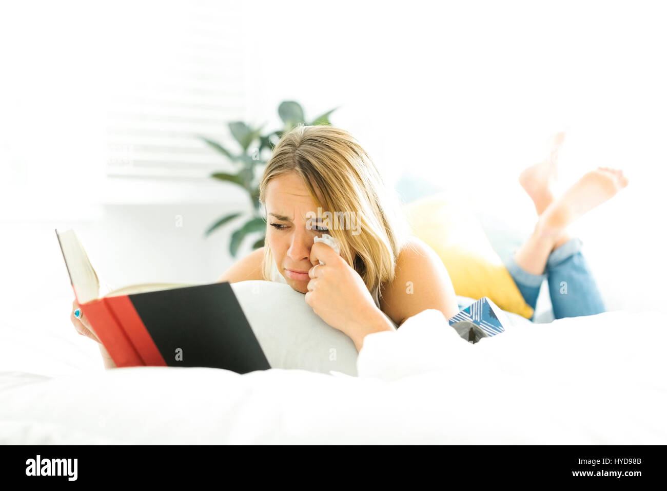 Young woman reading book and crying Stock Photo