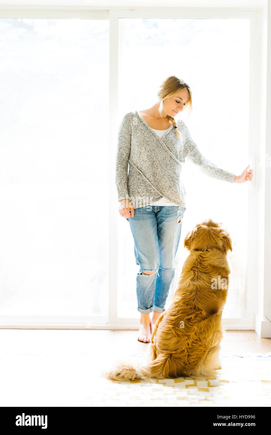 Young woman playing with golden retriever Stock Photo - Alamy