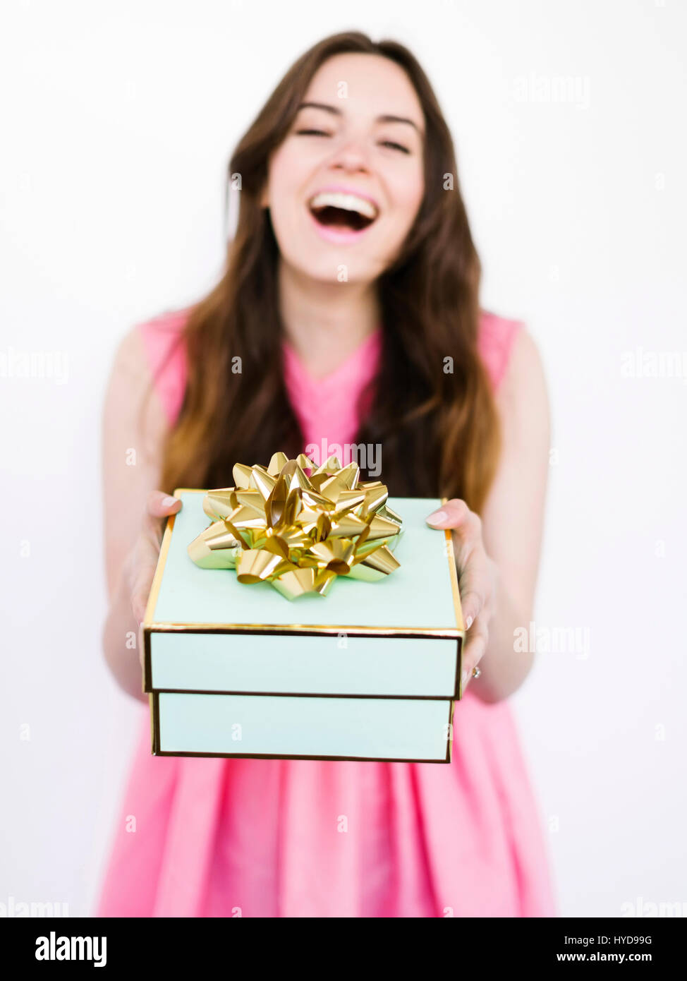 Mid adult woman holding gift box and laughing Stock Photo