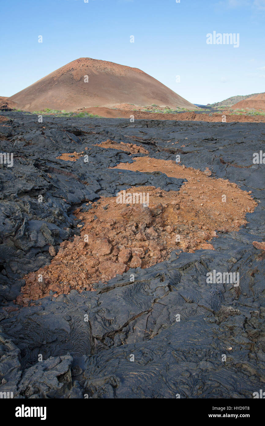 Volcano, hardened younger black pahoehoe lava flow on top of older oxidized and fragmented red aa lava flow, Santiago Island in the Galapagos Islands Stock Photo