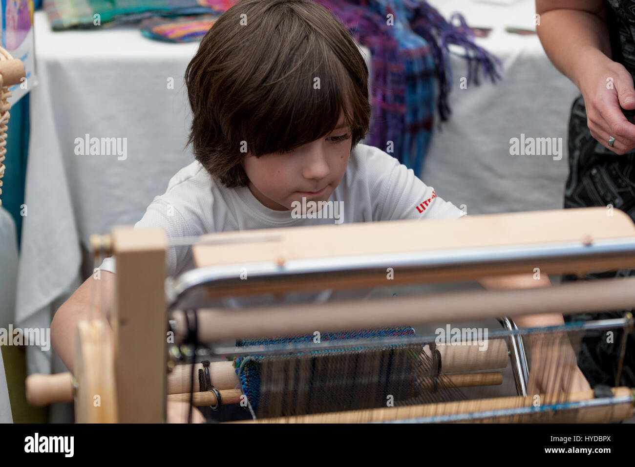 Young boy operating a modern weaving loom, uk Stock Photo Alamy