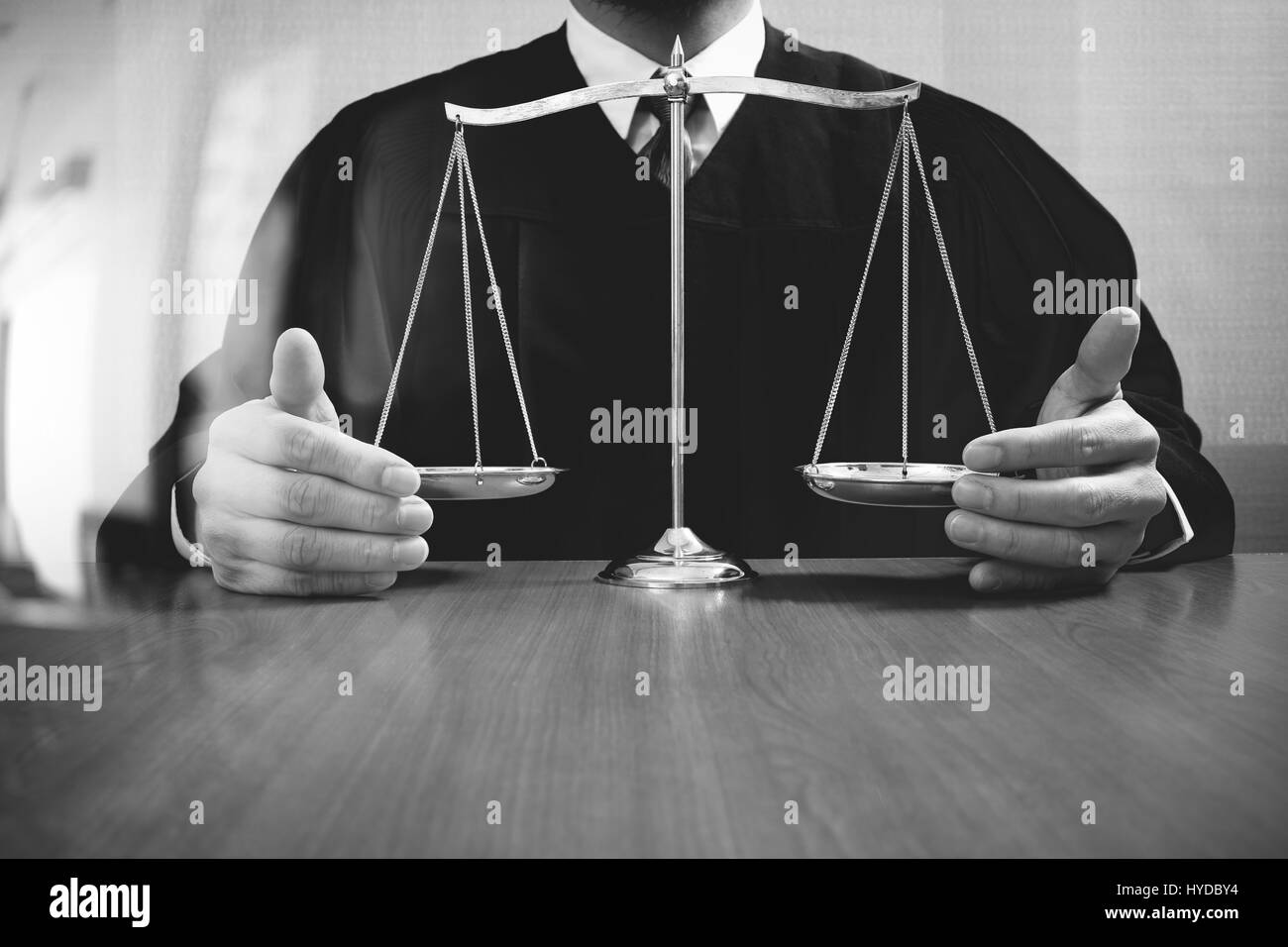 justice and law concept.Male judge in a courtroom with the balance scale on wood table,black and white Stock Photo