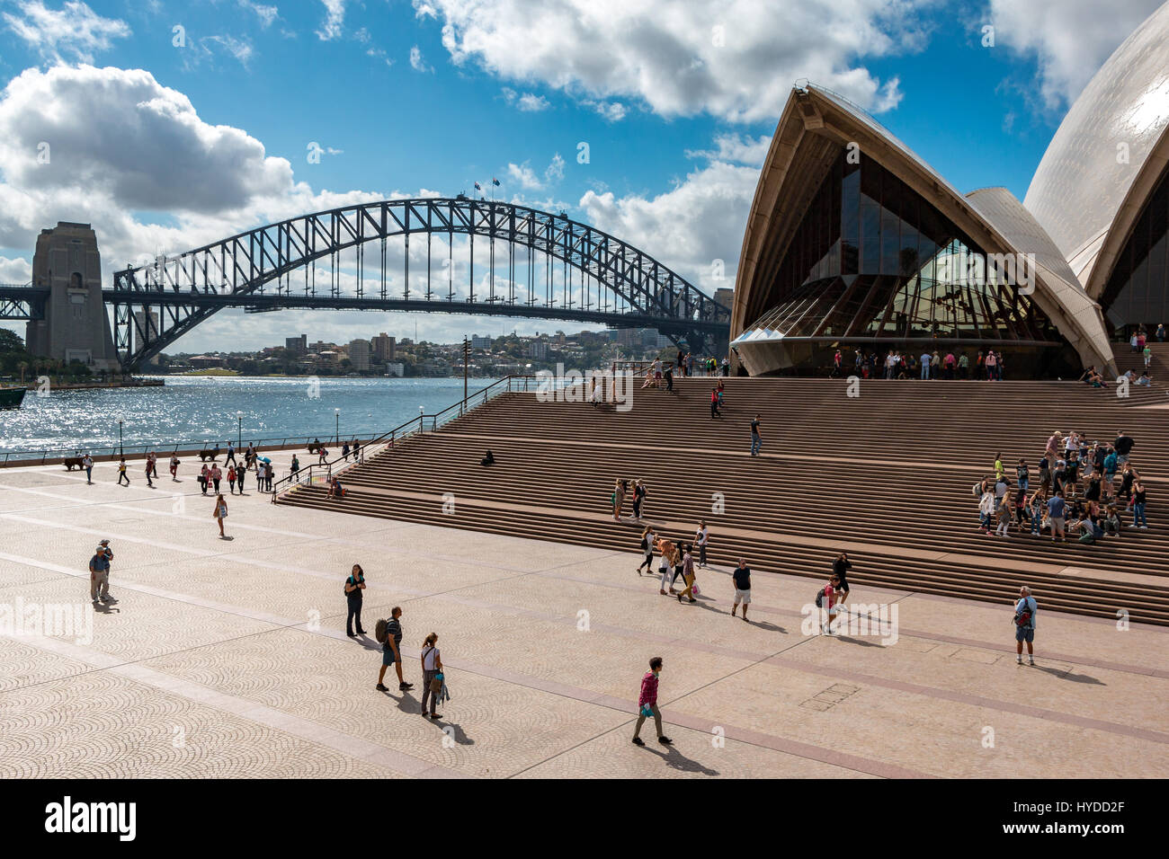 Tourists by the Sydney Opera House and Harbour Bridge on a sunny day Stock Photo