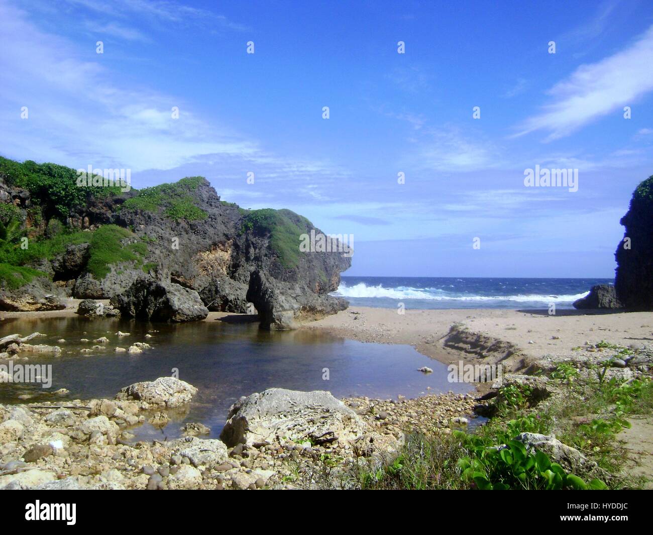 Hidden Beach, Saipan Located in Talafofo, the Hidden Beach is one of Saipan’s gems with lovely cliffs and stone formations. Stock Photo
